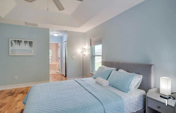 A bedroom with a bed, nightstand, and a ceiling fan.