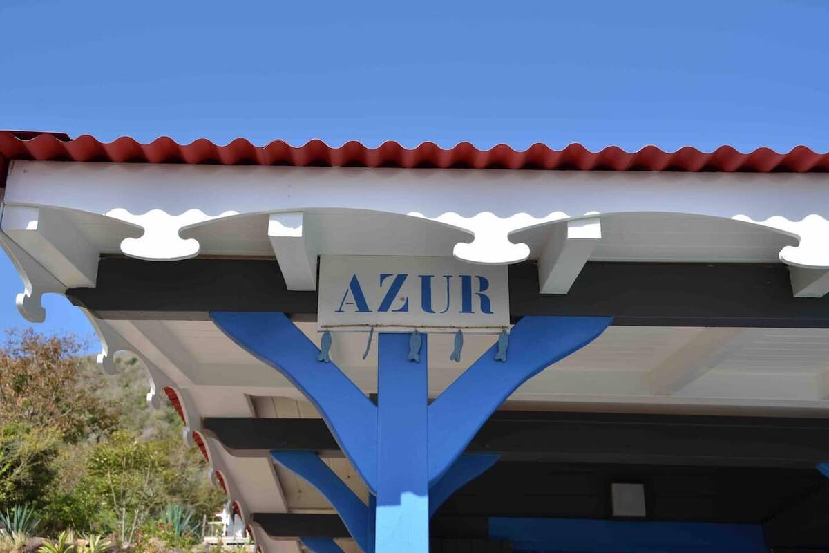 Un edificio con un letrero que dice "AZUR" y techo de tejas rojas.