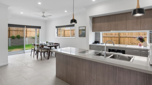 A modern kitchen with a large island, stainless steel appliances, and pendant lighting. - Brand New! Convenient Family Home w/ Workspace (Park Ridge)
