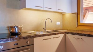 A kitchen with white cabinets, a stainless steel sink, and a built-in oven. - Cosy apartment for 6 people with WIFI, TV and balcony (Veysonnaz)