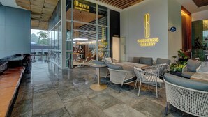 Ein modernes Interieur mit Café-Bereich, Sitzgelegenheiten und einem sichtbaren Schild mit der Aufschrift 'Marketing Gallery'.