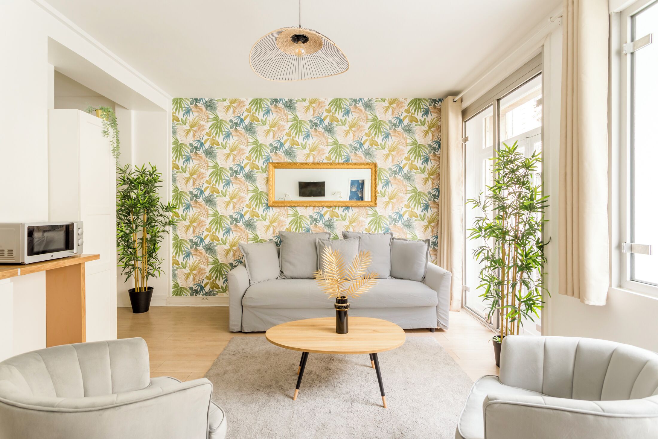 Ein modernes Wohnzimmer mit einer Couch, zwei Sesseln, einem Couchtisch und einer Topfpflanze.