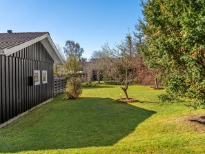 A residential property with a fenced yard, a small tree, and a building with a sloped roof. - "Hughlek" -  from the sea by Interhome (Hals)