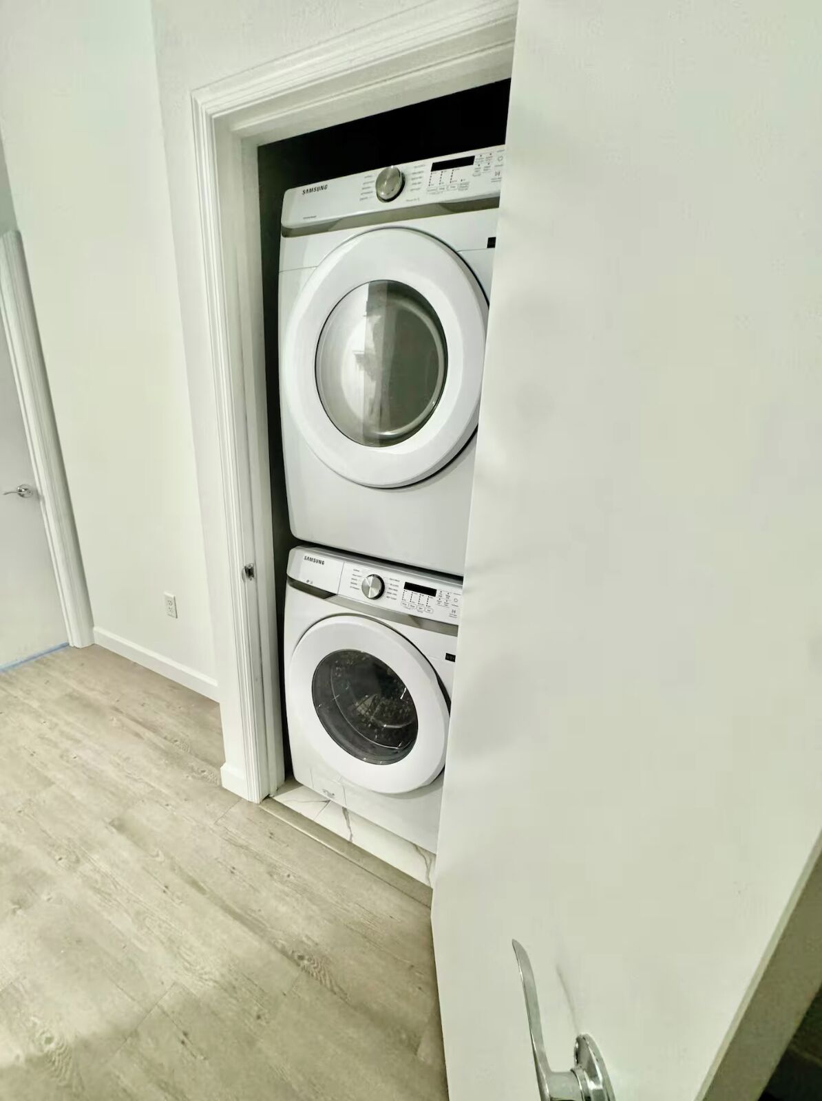 Una sala de lavandería con dos lavadoras apiladas.