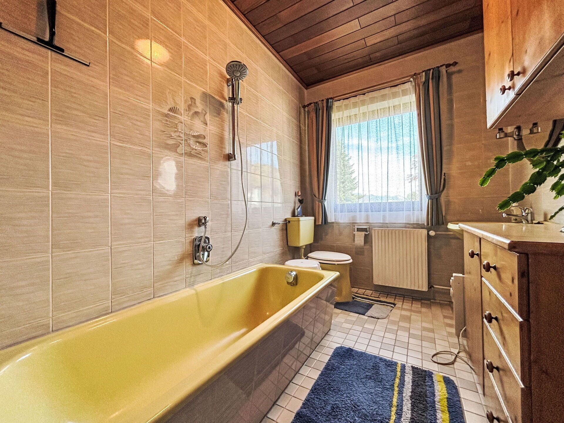Een badkamer met bad, toilet en wastafel.