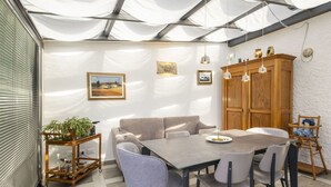 Un comedor con una mesa, sillas, un aparador de madera y una planta en maceta.