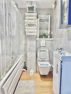 Ein Badezimmer mit Dusche, Toilette und Waschbecken.