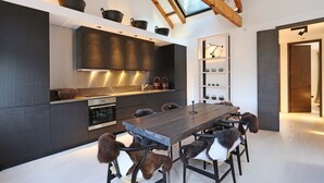 A modern kitchen with dark cabinetry, a stainless steel range hood, and a skylight above the counter. - Super Premium - Cadogan Square 3 Bedroom Apartment (London)
