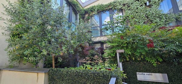 Un edificio con diversas plantas y arbustos, incluyendo un letrero que dice 'YachtingBond'.