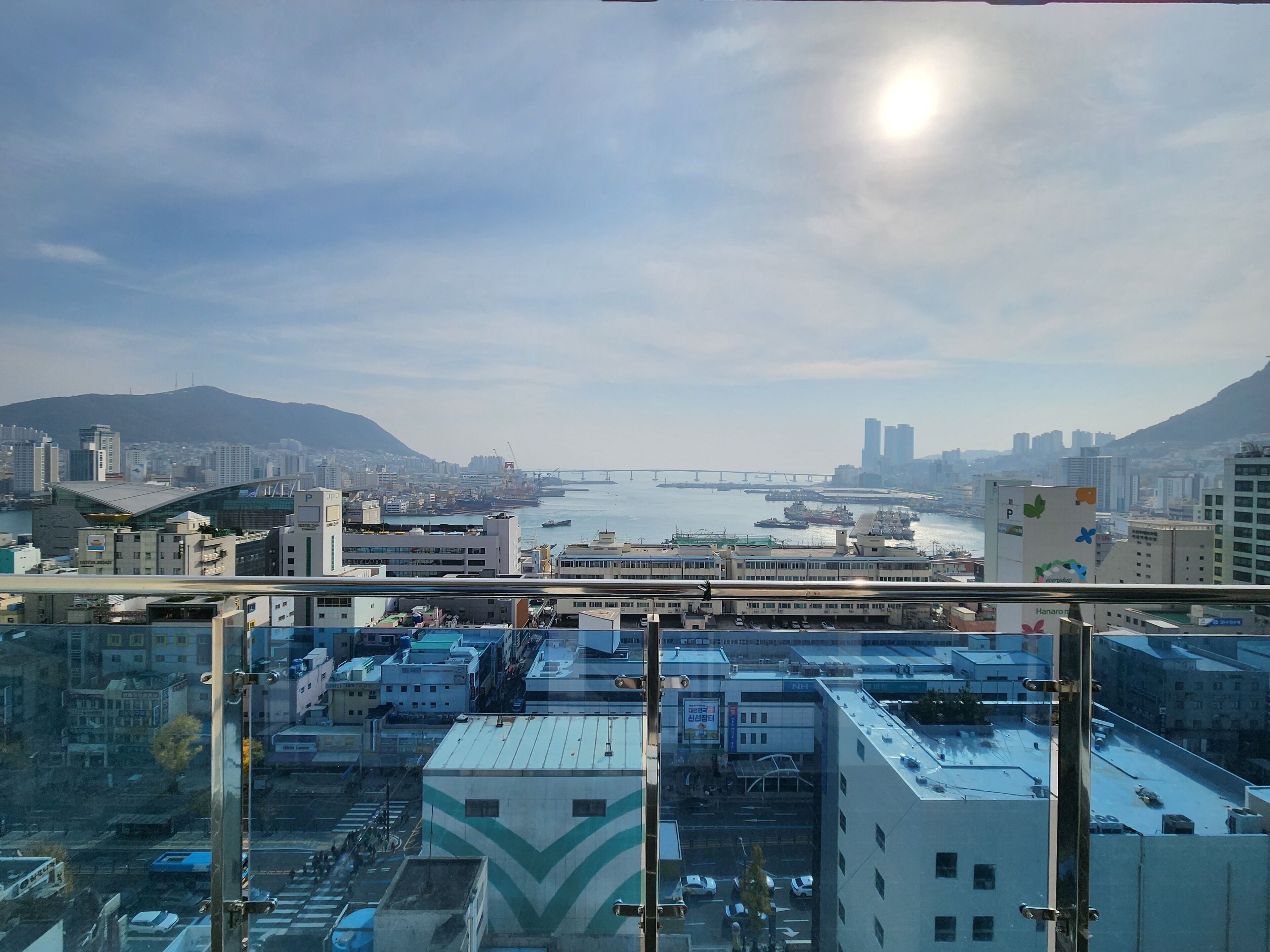 A cityscape with a view of the sea, buildings, and a bridge.