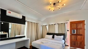 A hotel room with a bed, a bedside table, a mirror, a ceiling light fixture, and a door. - Semporna Water House (Semporna)