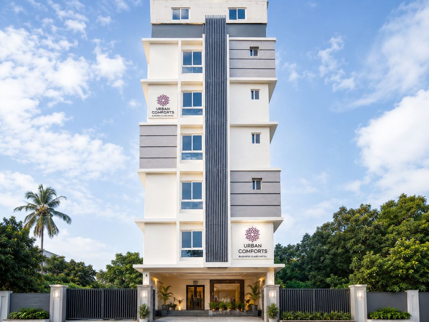 A multi-story building with a modern design, labeled 'URBAN COMFORTS BUSINESS CLASS HOTEL.'