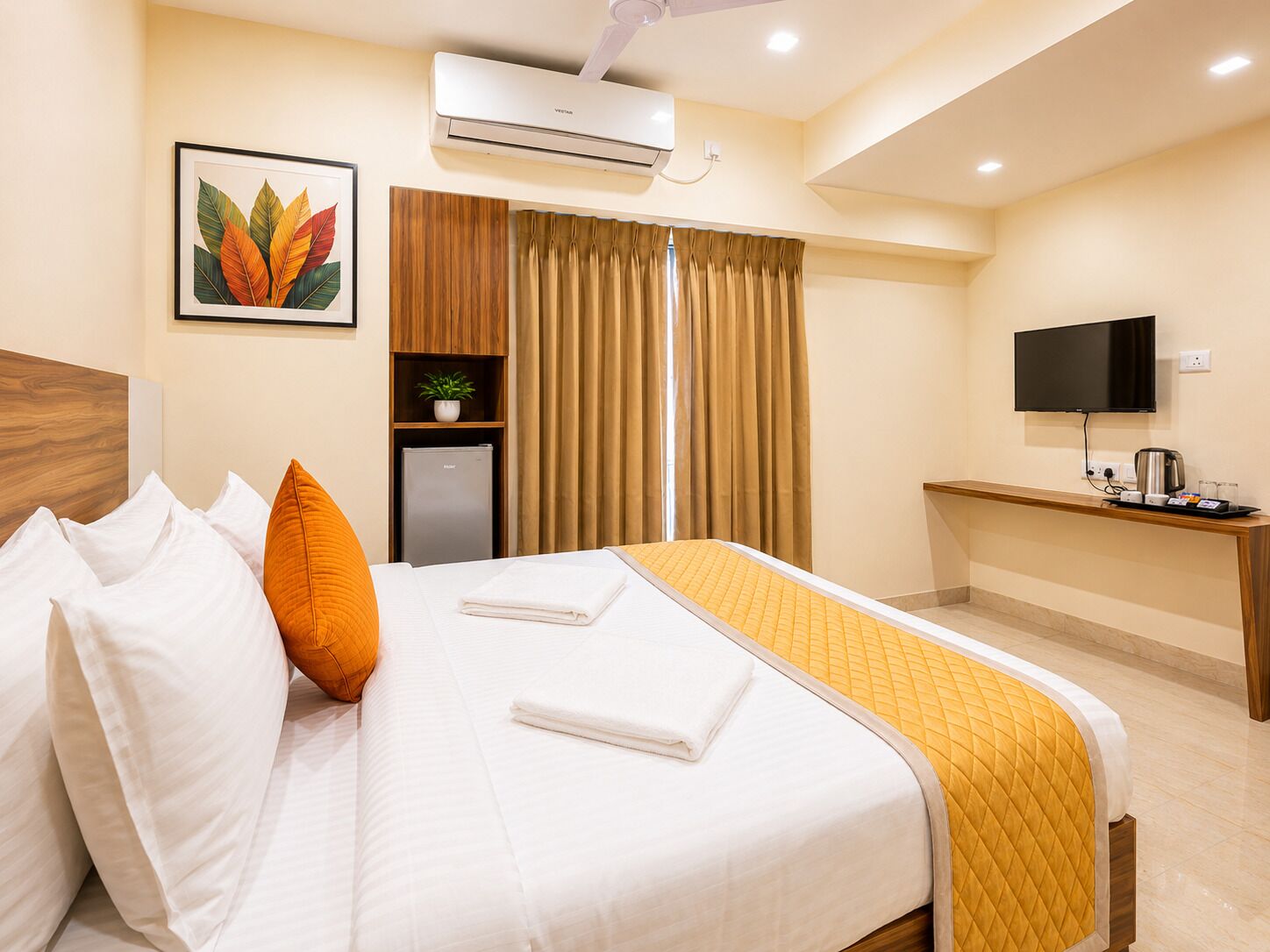 Una habitación de hotel con una cama, un escritorio, un televisor, aire acondicionado y una planta.