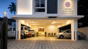 Un edificio moderno con un cartello che riporta 'URBAN COMFORTS BUSINESS CLASS HOTEL'.