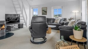 Una sala moderna con chimenea, muebles de cuero y vistas al exterior.