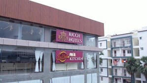 A hotel with a sign for Ricch Hotels and a Fire & Times Kitchen. - Ricch Hotels (Hyderabad)
