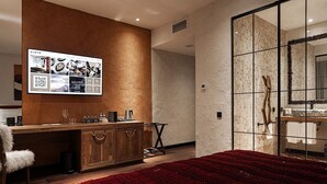 Habitación de hotel moderna con un armario de madera, una alfombra roja con textura y un espejo grande con un fondo de pared de ladrillo.