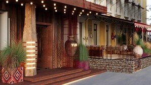 Fachada de hotel de madera, puerta de entrada con diseño y un letrero que dice "YUR".