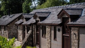 A row of stone buildings with pitched roofs and wooden doors.
