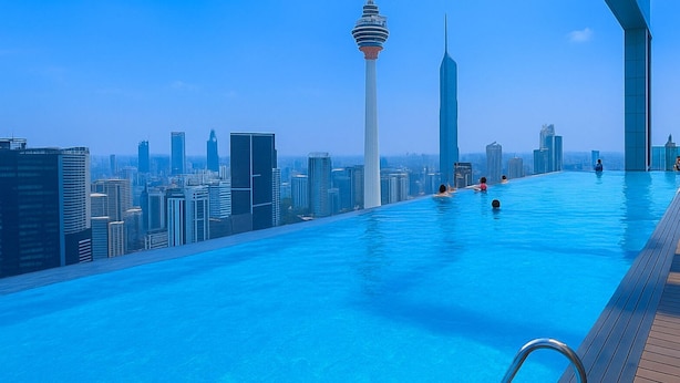 An infinity pool with a city skyline view, including a prominent tower. - The Platinum KLCC By Aura Suites (Kuala Lumpur)