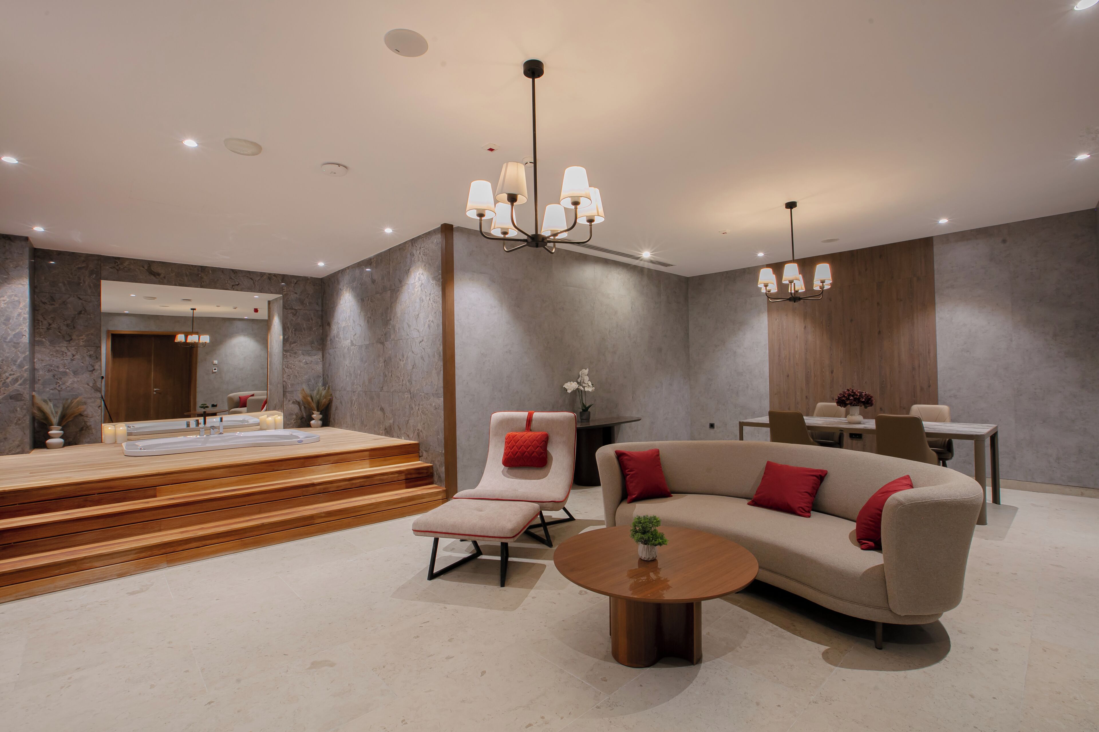 A modern living room with a sofa, a chair, a coffee table, and a dining area.