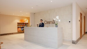 A reception desk with a sign that reads 'Cosmo' and a man standing behind it. - Lachin Resort & SPA (Lachin)