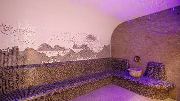 A mosaic-tiled bench with a stone wall and a small basin.