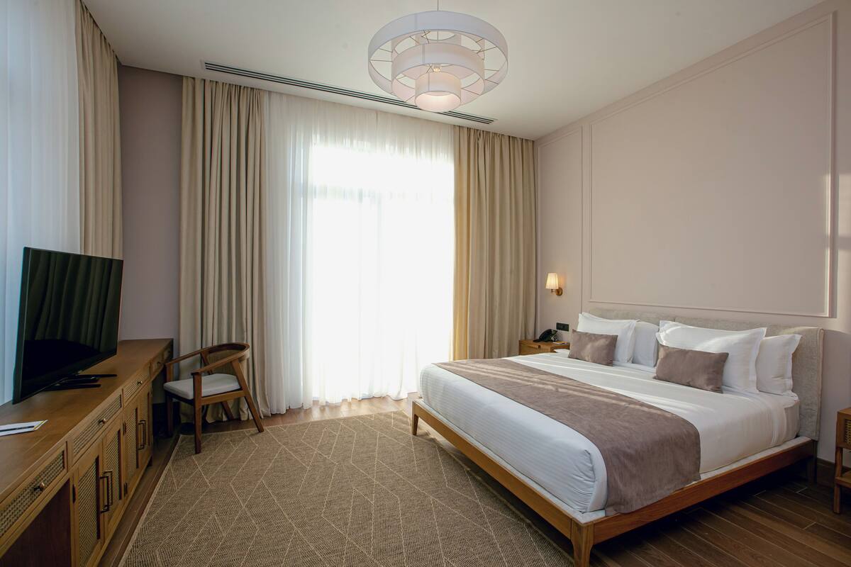 Une chambre d’hôtel équipée d’un lit, d’une télévision, d’un bureau et d’une chaise.