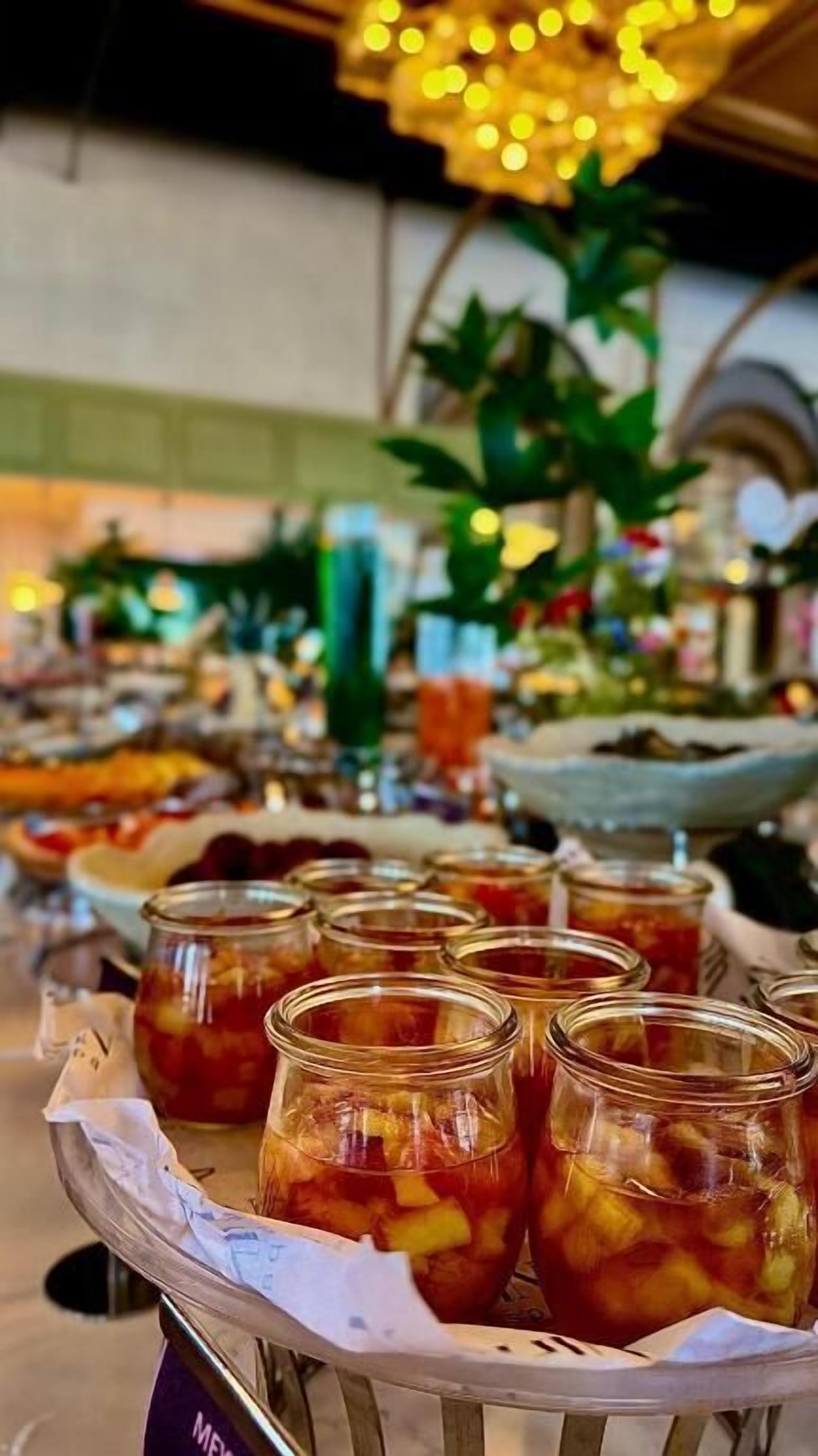 Een presentatie van eten met potten ingelegde vruchten en groenten.