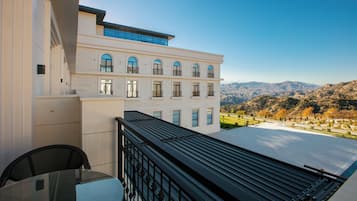 A modern building with a balcony overlooking a mountainous landscape.