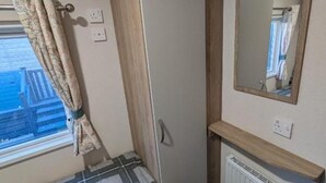 A small bathroom with a window, a mirror, and a radiator.