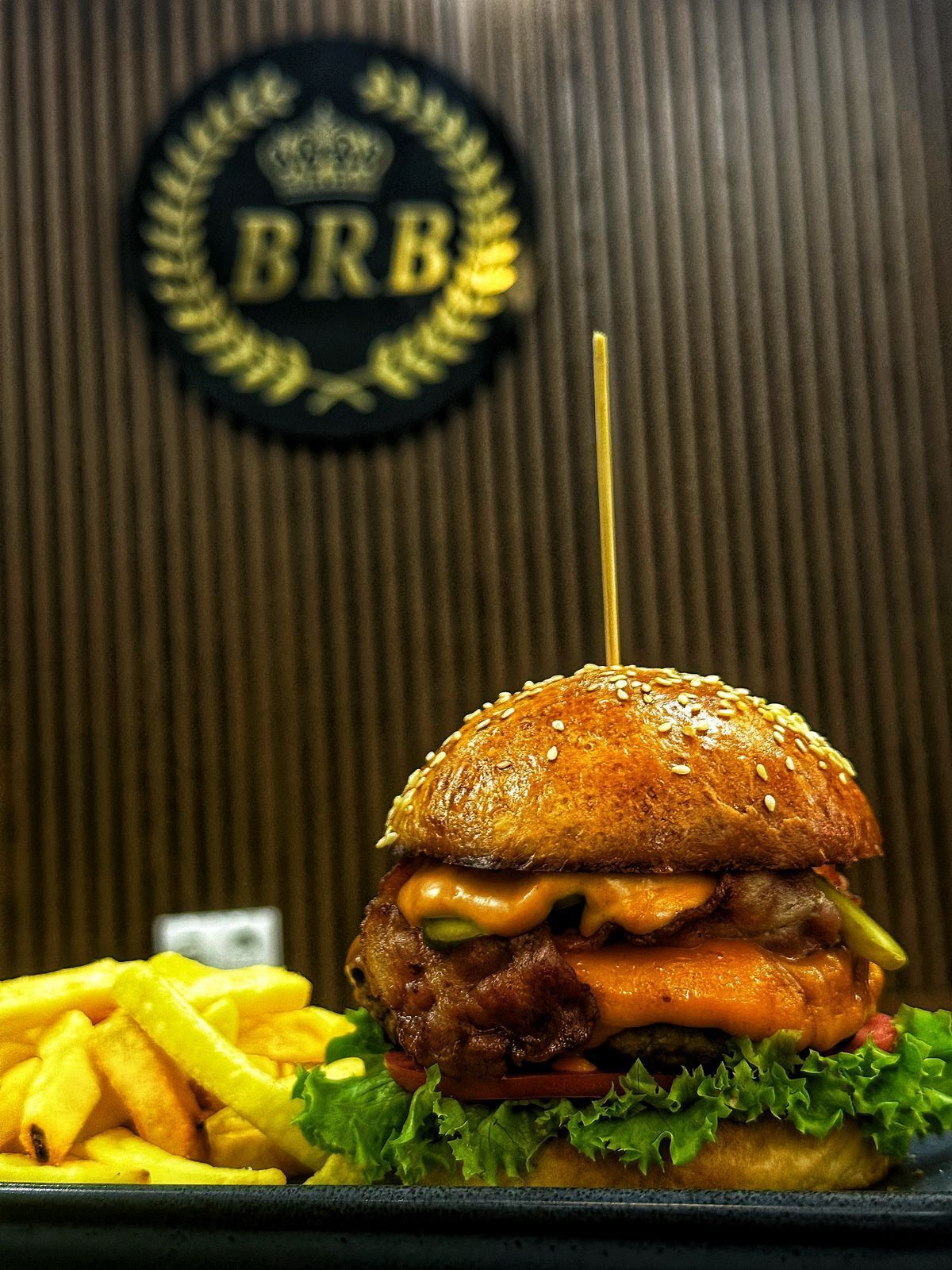 Una hamburguesa con papas fritas y un logotipo en la pared.