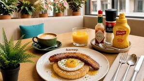 A breakfast setting with a plate of eggs, bacon, and toast, a cup of coffee, and condiments on a table. - HOMA Chalong Bay (Chalong)