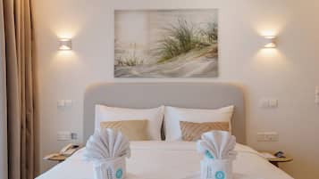 Une chambre d’hôtel avec un lit, deux tables de chevet, un tableau et des lampes fixées au mur.
