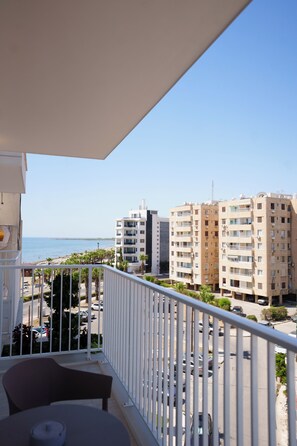 A balcony with a view of a beach and a parking lot. - Dinglis Beach Hotel Suites (Larnaca)