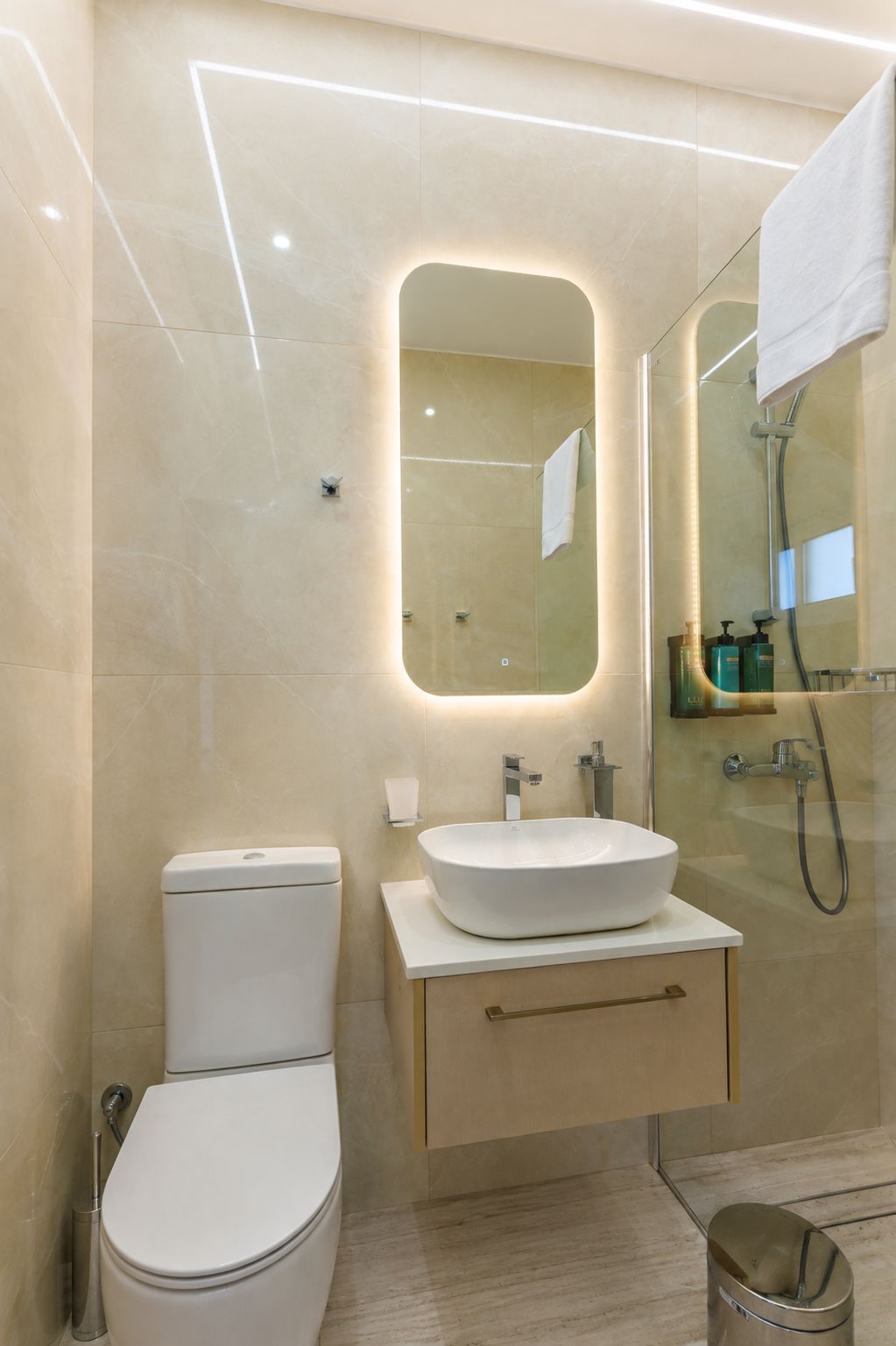 Un baño moderno con inodoro, lavamanos y ducha.