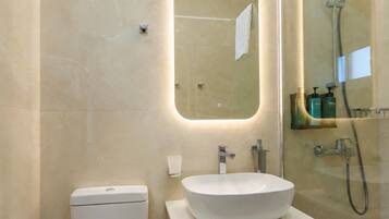 Un baño moderno con inodoro, lavamanos y ducha.