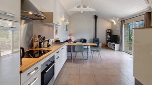 A modern kitchen with a central island, built-in oven, and stainless steel range hood. - Holiday Home “La Cense De La Mérelie - Le Logis” with Shared Pool, Wi-Fi and Air Conditioning (Saint-Geniès)