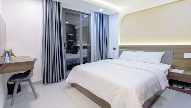 A modern hotel room with a bed, a desk, and a chair. - LUMIA HOTEL (Ho Chi Minh City)