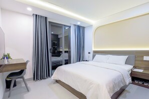 Ein modernes Hotelzimmer mit einem Bett, einem Schreibtisch und einem Sessel.