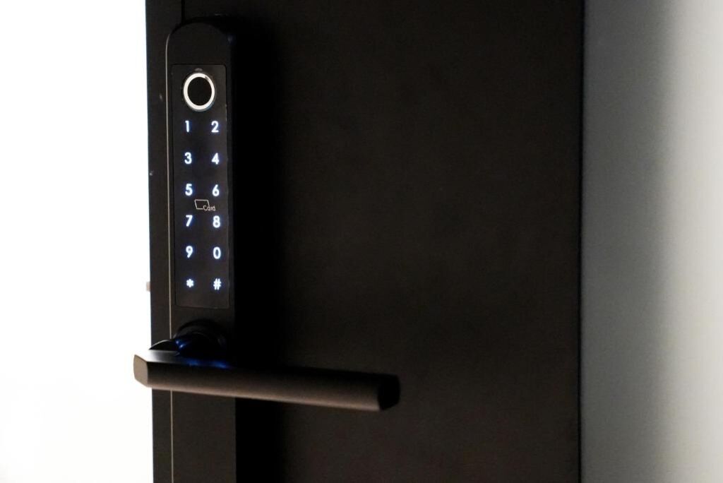 Une porte moderne dotée d’un clavier numérique et d’une poignée horizontale.