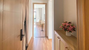 A hallway with a wooden door labeled "301", a radiator, and a potted plant.