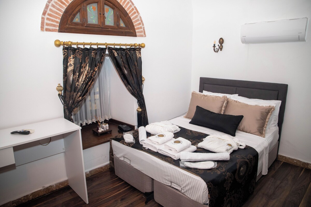 Une chambre d’hôtel avec un lit, une table de chevet et un bureau.