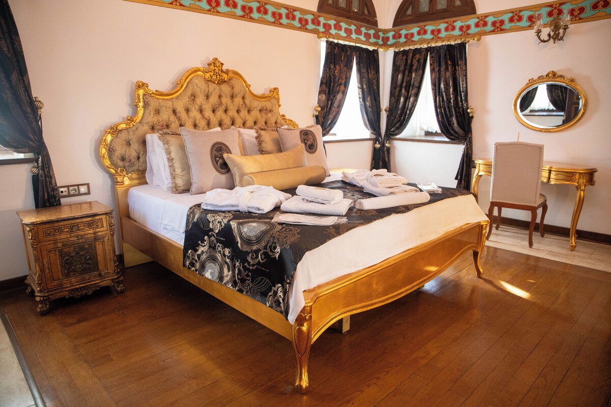 Une chambre à coucher luxueuse, dotée d’un grand lit, d’une tête de lit décorée et d’un style classique.