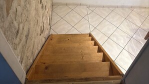 A staircase with a wooden handrail leading to a tiled floor. - Apparently from the countryside (La Croix-sur-Ourcq)