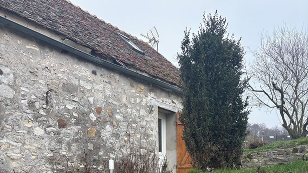 A stone building with a tiled roof, a wooden door, and a stone staircase leading up to a higher level. - Apparently from the countryside (La Croix-sur-Ourcq)