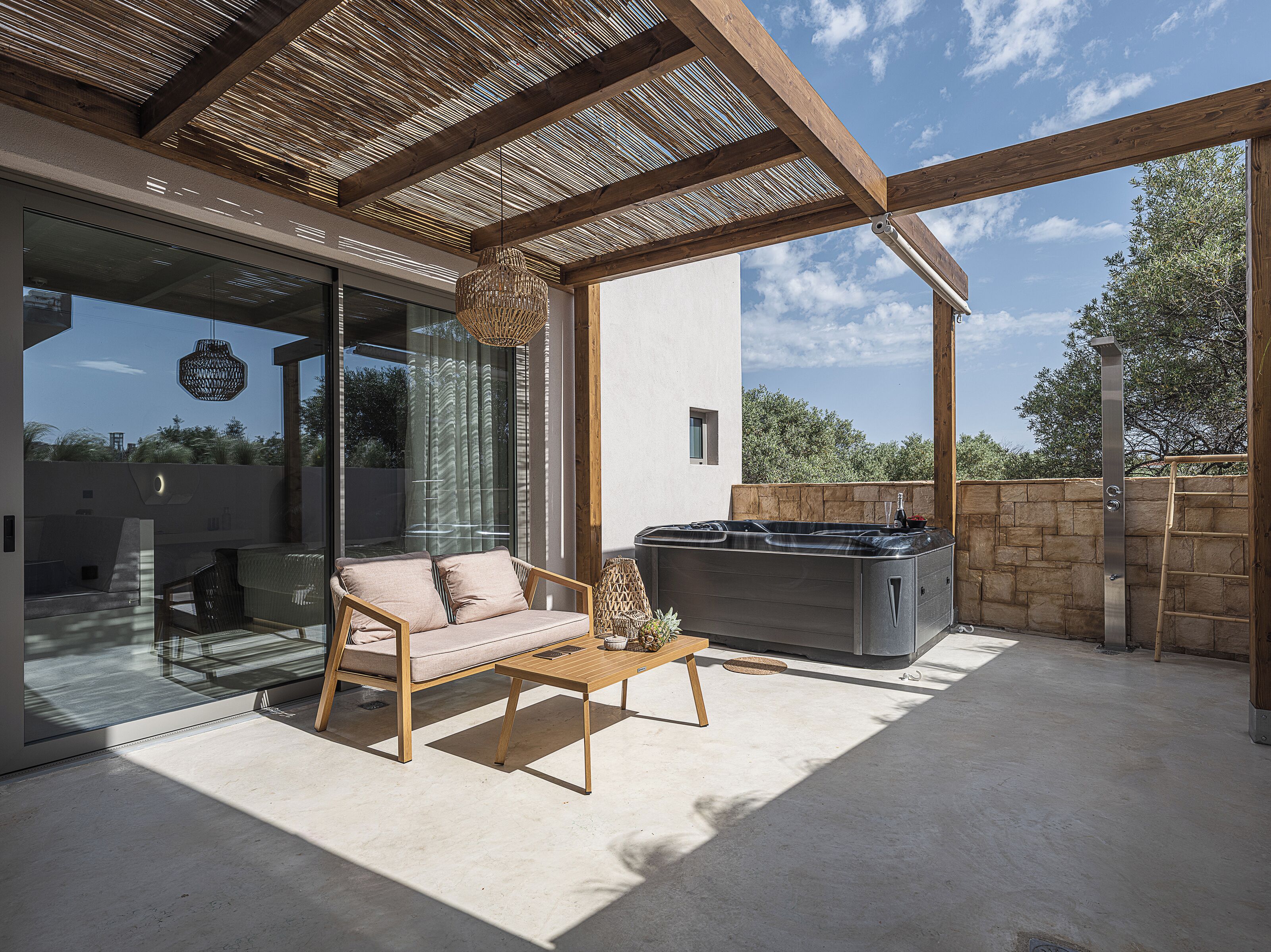 Eine Terrassenanlage im Freien mit einer Couch, einem Tisch und einem eingebauten Grill.
