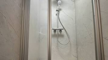 Chuveiro, secador de cabelo, toalhas de banho