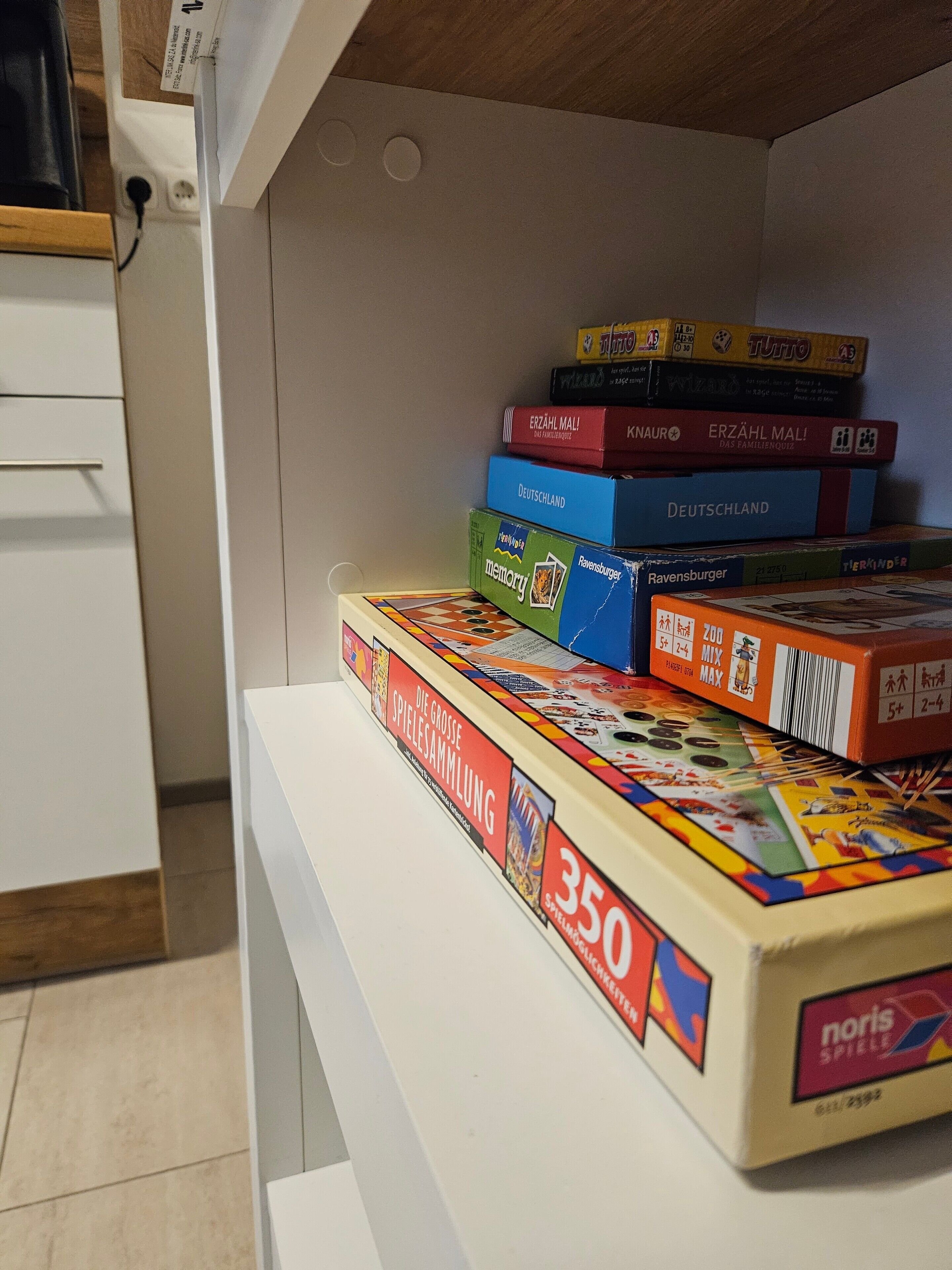 A shelf with various board games and books.