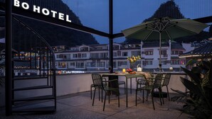 Ein Hotelbalkon mit Tisch, Stühlen und Sonnenschirm.